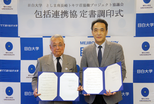 協定書を手にする佐藤学長(右)と足立会長