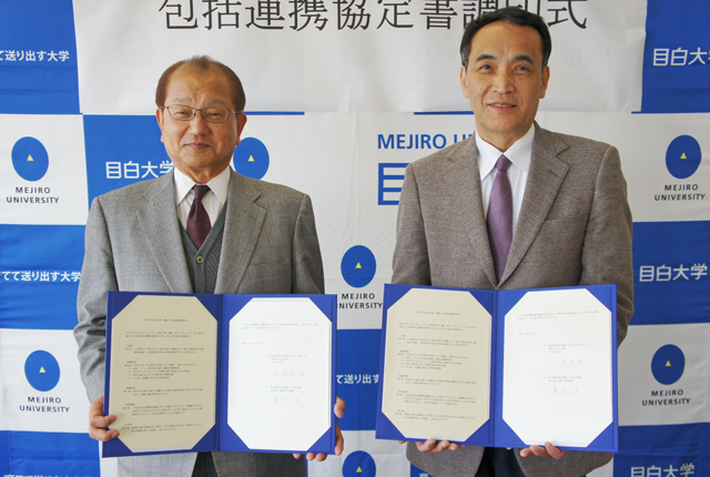 協定書を手にする佐藤学長(右)と菊池公男代表取締役